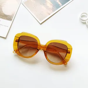 Detailed view of large round sunglasses with gradient brown lenses and amber acetate frame.