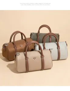 Petit sac Boston en nylon imperméable avec poignées contrastées et design cylindrique classique.