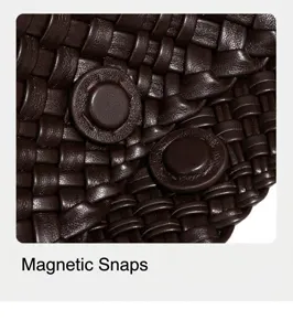 Detalle de bolso de mano tejido en cuero marrón, textura suave y cierre magnético para uso.