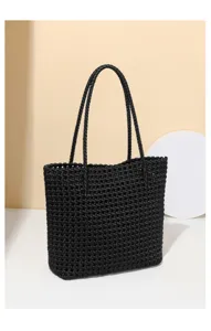 Vue détaillée du sac cabas tressé noir avec sa texture en grille et ses lanières solides.