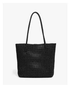Vue détail d'un sac cabas tressé noir mettant en valeur le motif et les poignées robustes.