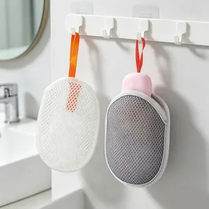Detailed view of mesh soap foaming nets hanging neatly on a bathroom wall hook.
