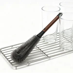 Detail shot of the long handle bottle cleaning brush with grey bristles on a drying rack.