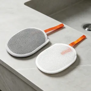 Detail shot of oval mesh foaming nets with orange hanging loops on stone countertop surface