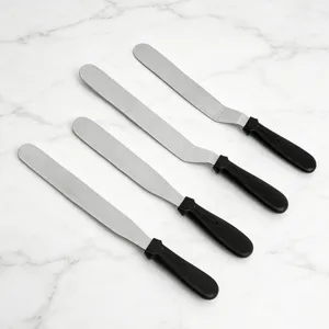 Stainless steel cake spatula set with black handles for baking and frosting. Detail view.