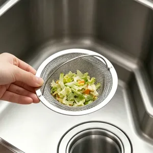 Détail de passoire d'évier de cuisine en acier inoxydable avec maille fine et restes.
