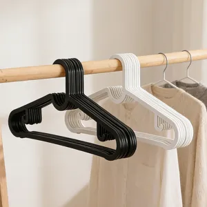 Detailed view of thick plastic clothes hangers in black and white, featuring non-slip design.