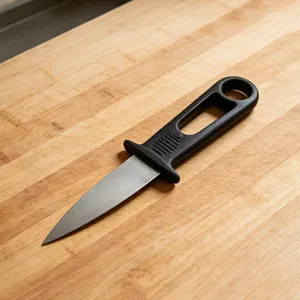 Stainless steel oyster shucking knife detail, sturdy seafood knife with black handle.