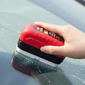 Car glass oil film removal brush detailing view, windshield cleaning tool in hand for clear view.