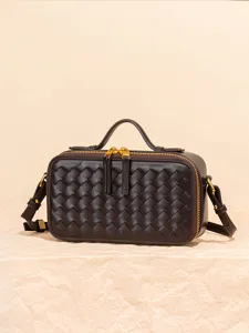 Sac bandoulière miniature en cuir tressé marron foncé avec poignée et doubles fermetures.