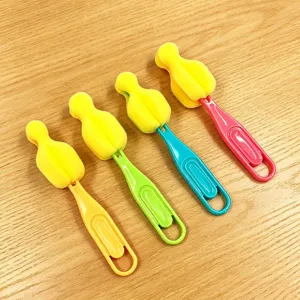 Detalle del cepillo de esponja para biberón colorido con agujero para limpieza diaria.