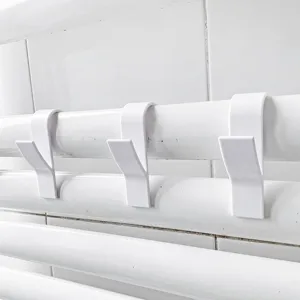 Close-up van witte radiatorhaken, duurzame plastic handdoekhouder voor de badkamer.