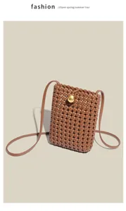 Detailed view of brown woven leather phone bag with gold clasp texture and slim strap.