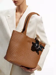 Élégant sac cabas tressé marron en cuir avec charm chien, sac porté épaule grand format tendance.