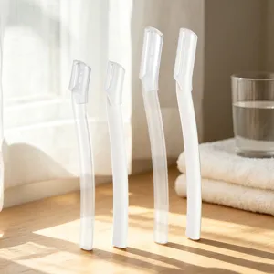 Detail view of safety eyebrow razors with protective caps in white, designed for easy grooming.
