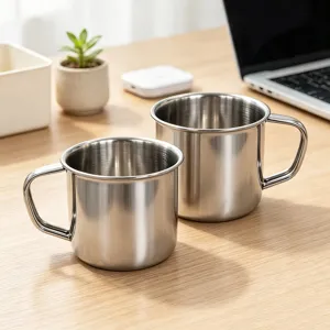 Primo piano tazza in acciaio inox, finitura metallica con comodo manico per uso quotidiano.