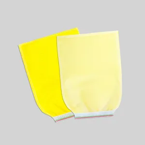 Primer plano de guantes de baño exfoliantes amarillos desechables, tejido texturado para ducha.