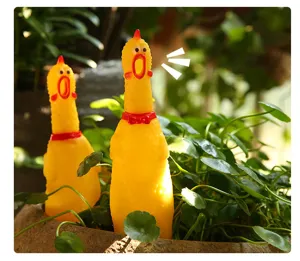 Detail view of yellow rubber screaming chicken toys creatively placed inside a green potted plant.