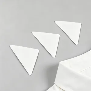 Dettaglio dell'adesivo di supporto per colletto di camicia bianco triangolare antiriarricciatura.