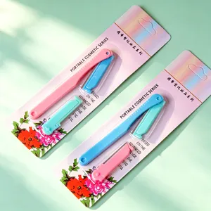 Close-up detail of portable foldable eyebrow razors with pink and blue handles and blades.