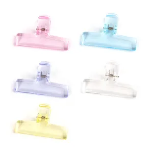 Translucent colored plastic spring clips for office document organization and desktop storage.