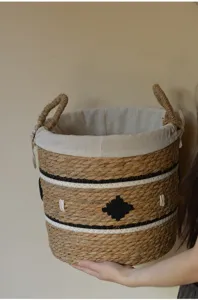 Panier a linge en jonc de mer tresse avec doublure interieure et poignees de rangement.