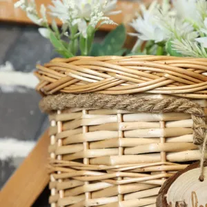 Handwoven wicker hanging basket detail with natural rope and white floral decor for home wall.