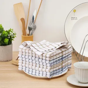 Strofinacci da cucina in cotone tessuto waffle spessi impilati su piatto per stoviglie.