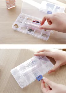 Clear plastic jewelry storage box detail, multi-grid organizer for small accessories and rings.