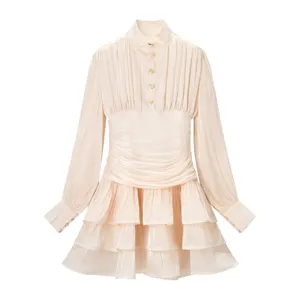 Chique champagnekleurige mini-jurk met lange mouwen, opstaande kraag en gelaagde volants.
