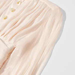 Detail van elegante Franse roze plissé jurk met delicate gouden parelknopen voor dames.