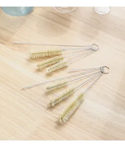 Multifunctional cleaning brush set for straws and spouts, detailed view on wooden table.