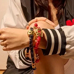 Woven rope bracelet featuring 3D digital metal charms worn on wrist in lifestyle shot main view.