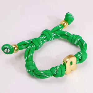 Detail des gruenen geflochtenen Seils mit 18k vergoldetem Buchstaben R Anhaenger.