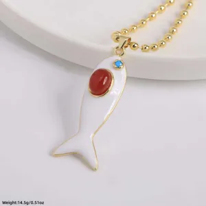 Detailed close-up of a white enamel fish pendant necklace with red and blue gemstone accents.