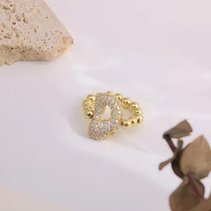 Detail view of a fashion copper micro-inlaid zircon letter ring with elegant 18K gold plating.