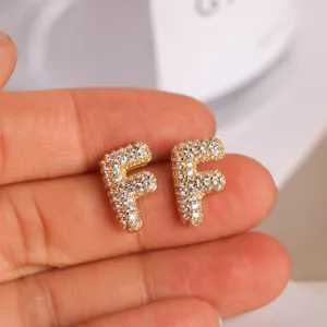 Close-up of the gold-plated letter F stud earrings with sparkling pave cubic zirconia details.
