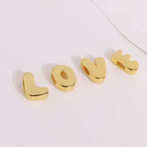 Gold letter bubble pendants detail shot showing smooth metallic alphabet charms for DIY necklace.