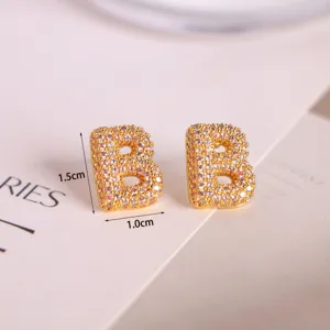 Close-up detail of luxury gold-plated letter B stud earrings with micro-paved sparkling cubic zirconia.