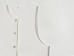 Detailansicht der minimalistischen einfarbigen Leinen ärmellosen Weste Kragen und Knopf Nahaufnahme.