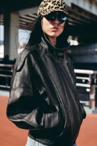 Women's black litchi grain leather jacket, stylish double collar street style detail.