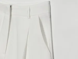 Nahaufnahme der weißen Damen-Kurzhose mit eleganten Bundfalten und praktischen Gürtelschlaufen.