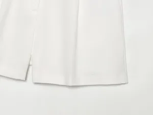 Weiße Leinenshorts Detailaufnahme, minimalistischer Sommerschnitt für Damenmode.
