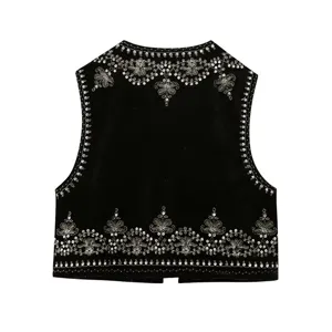 Detail view of black velvet vest with intricate gold bead and sequin embroidery hem.