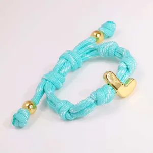 Türkisblaues geflochtenes Armband mit goldfarbenem Buchstabenanhänger für Damen mode.