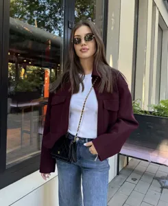 Detail view of the stylish women's woolen lapel pocket jacket in a rich burgundy color.