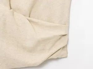 Close-up of premium beige linen fabric showing natural texture and fine stitching details.