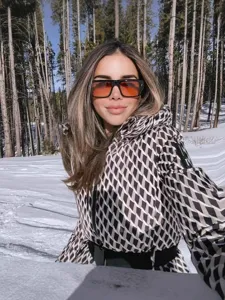 Women's winter warm hooded ski jacket with geometric diamond pattern and waist belt for snow.