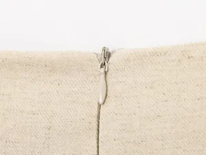 Close-up detail of a beige linen fabric garment featuring a neat zipper closure.