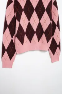 Roze en donkerbruine argyle gebreide trui detail, klassiek geometrisch patroon, gezellig.